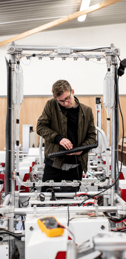 A man on the phone using a keyboard near a machine.