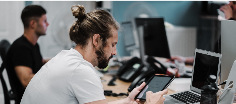 Two people sitting at a desk, working on their computers. 